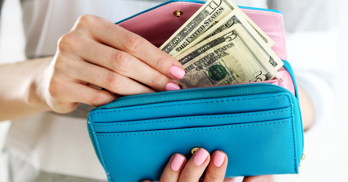 a woman holding cash from her blue wallet