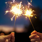 Two New Years sparklers burning on night background.