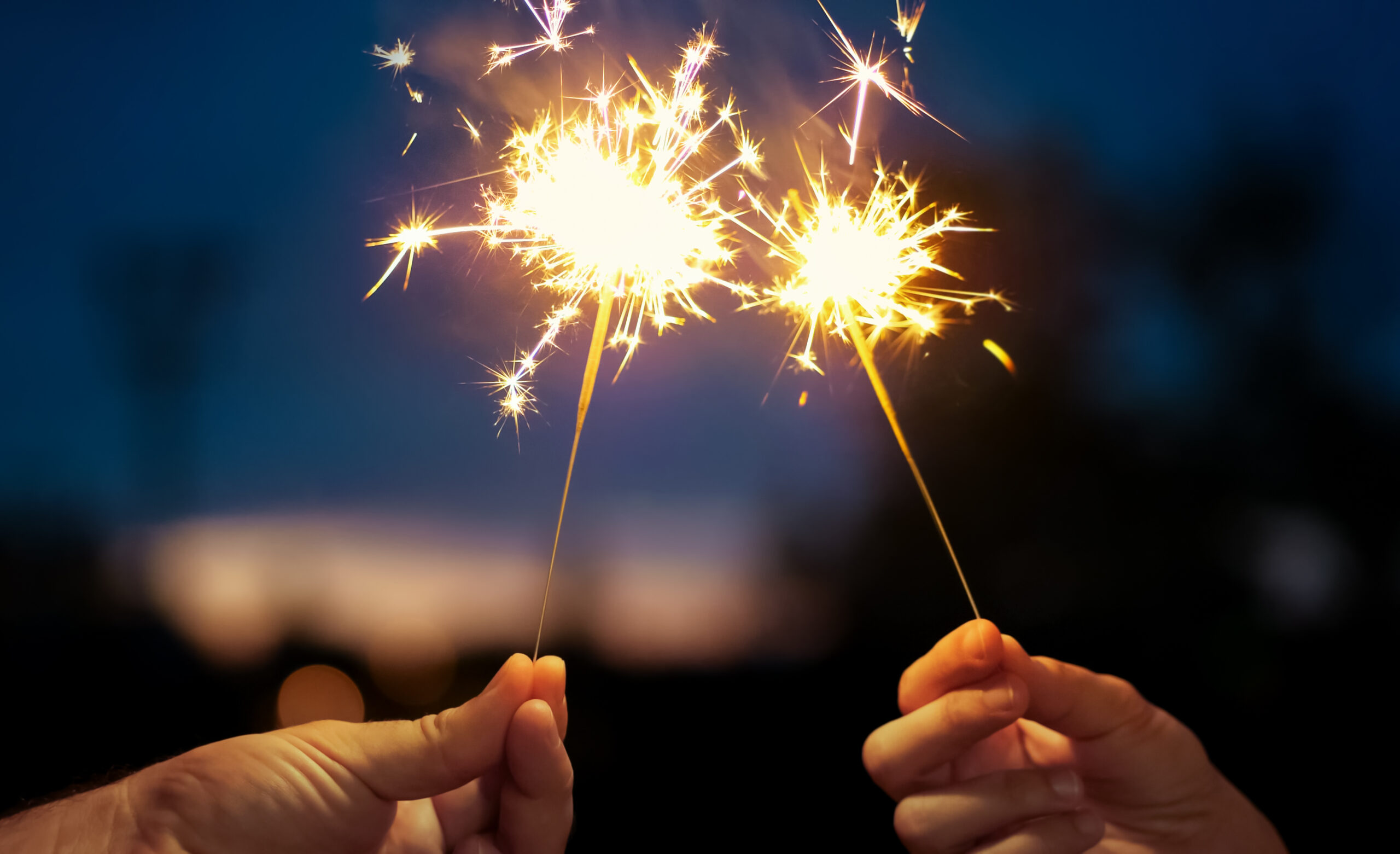 Two New Years sparklers burning on night background.