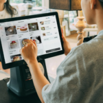 A cashier assisting a customer by using a virtual terminal to take their order.