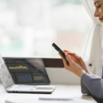 Independent sales woman working on phone and laptop