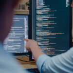 Two developers reviewing code together at monitors